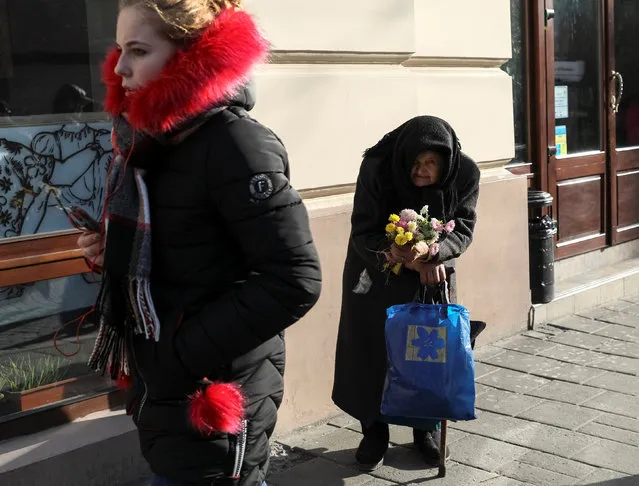 A woman waits for customers as she sells flowers in central Lviv, Ukraine, November 24, 2016. (Photo by Gleb Garanich/Reuters)