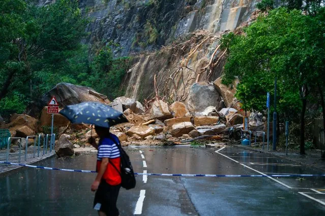 A man views the debris of a landslide blocking a road following torrential rains hitting the city, in Hong Kong, China, 08 September 2023. The government has stopped schools and several public services while bus services of a major operator have been suspended, amid a black rainstorm alert, the highest level of the city's weather system. (Photo by Daniel Ceng/EPA/EFE/Rex Features/Shutterstock)