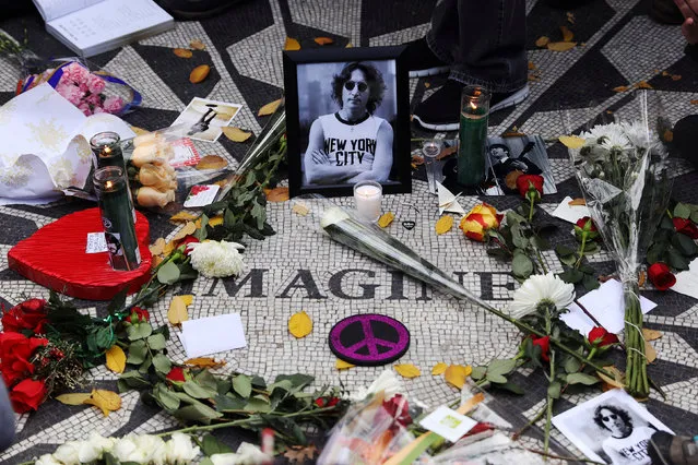 A picture of former Beatle John Lennon is seen among flowers and candles at the Imagine mosaic in the Strawberry Fields section of New York's Central Park to mark the 36th anniversary of his death, in New York, NY, U.S., December 8, 2016. (Photo by Mark Kauzlarich/Reuters)
