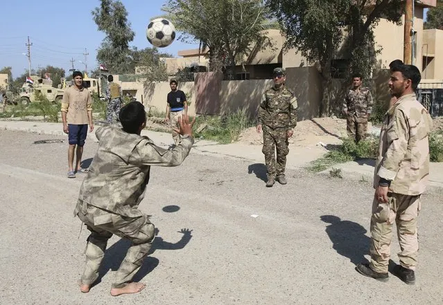 Iraqi security forces and Shi'ite fighters play soccer at Udhaim dam, north of Baghdad March 1, 2015. Iraqi soldiers and pro-government Shi'ite militias had been massing in preparation for an attack on Islamic State strongholds along the Tigris River to the north and south of Tikrit, hometown of executed former president Saddam Hussein.  REUTERS/Thaier Al-Sudani 