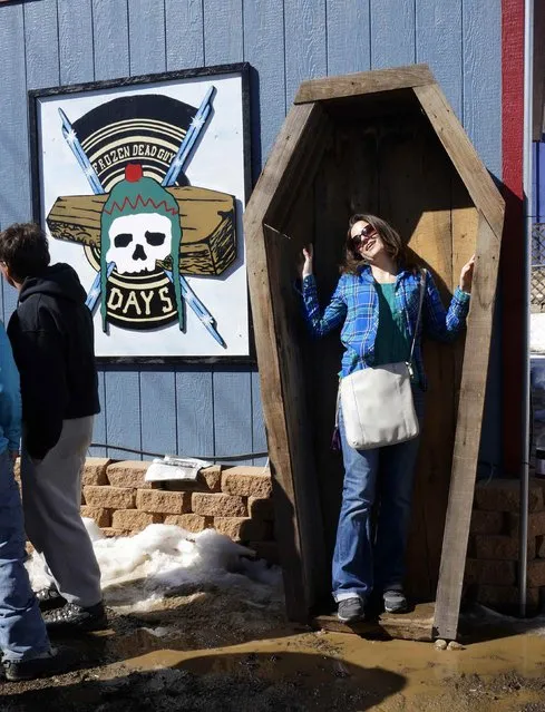 A woman poses for a photo in a coffin-shaped box at Frozen Dead Guy Days in Nederland, Colorado March 14, 2015. (Photo by Rick Wilking/Reuters)