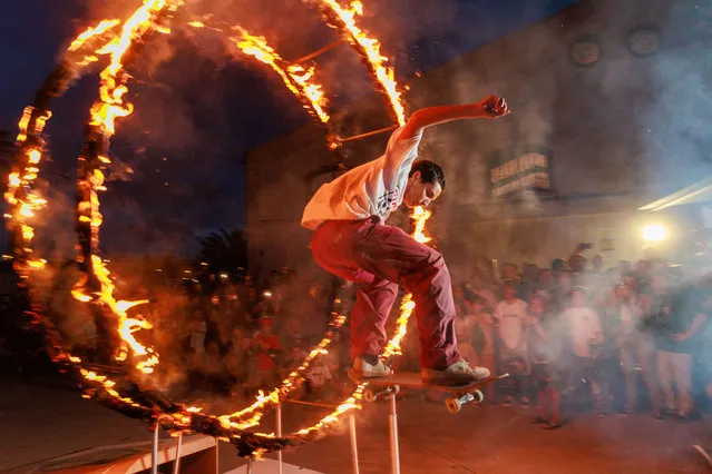 A skater jumps through a ring of fire at the La Bodega Skate facilities as part of one of the Vans contests to showcase the top street skaters in Europe on September 16, 2023 in Jerez de la Frontera, Spain. (Photo by Juan Carlos Toro/Getty Images)