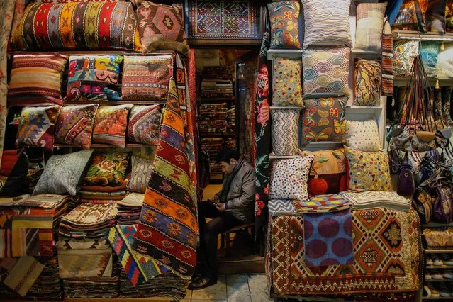 A shop owner sits inside Istanbul's centuries-old Grand Bazaar, Monday, February 1, 2016. In a news conference Monday, the municipality of the city's Fatih district announced its plans for the renovation of the iconic maze of shops, restaurants and tea houses. The complex, which houses nearly 4,500 stores, starred in the 2012 James Bond movie, “Skyfall”. (Photo by Emrah Gurel/AP Photo)