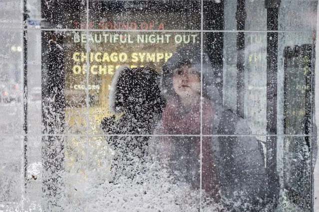 Morning commuters wait for CTA busses near Union station in Chicago. A wintry storm brought blizzard-like conditions to parts of the Midwest early Monday, November 26, 2018, grounding hundreds of flights and causing slick roads for commuters as they returned to work after the Thanksgiving weekend. (Photo by Rich Hein/Chicago Sun-Times via AP Photo)