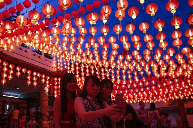 Malaysian ethnic Chinese women take a selfie under illuminated traditional Chinese lanterns on the eve of Lunar New Year in Kuala Lumpur, Malaysia, Sunday, February 7, 2016. (Photo by Joshua Paul/AP Photo)