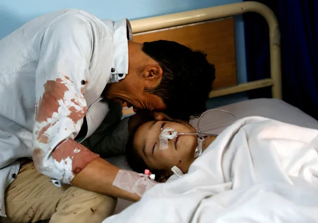 A man cries beside an injured girl at a hospital after a suicide attack in Kabul, Afghanistan, April 22, 2018. (Photo by Mohammad Ismail/Reuters)