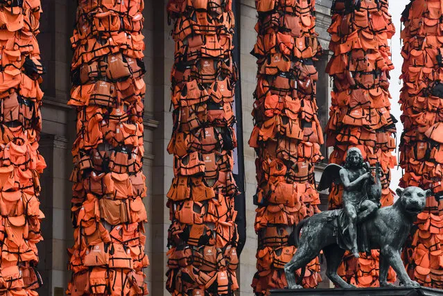 An art installation by Chinese artist Ai Weiwei that consists of life vests worn by refugees bound to the columns of the concert house next to a statue at Gendarmenmarkt on February 14, 2016 in Berlin, Germany. The life vests were among the thousands discarded by migrants and refugees after they crossed the sea from Turkey to Greece. Ai Weiwei lives in Berlin and is currently involved in several projects relating to refugees. Up to 80,000 refugees currently live in Berlin and the city is preparing for the likely arrival of 30,000 more in 2016. (Photo by Clemens Bilan/Getty Images)