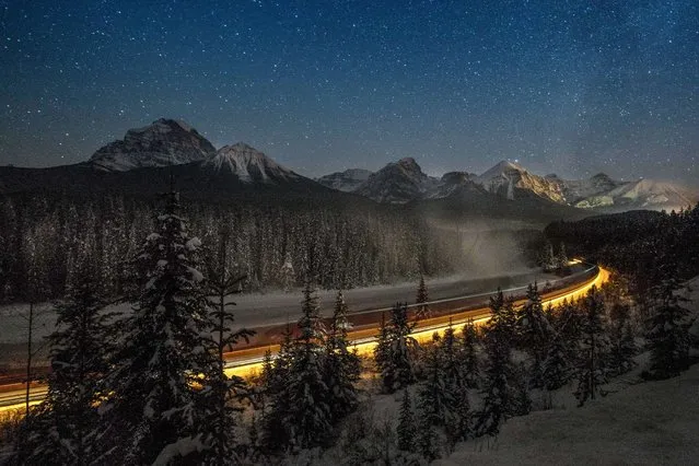Cargo train passes through the famous “Morant's Curve” offering a beautiful view of the frozen Bow River and the Canadian Pacific Railway at Banff National park near Lake Louise, Canada, late on December 6, 2013. The regions temperatures dropped to minus 36 degrees of Celsius (32.8 Fahrenheit). (Photo by Joe Klamar/AFP Photo)