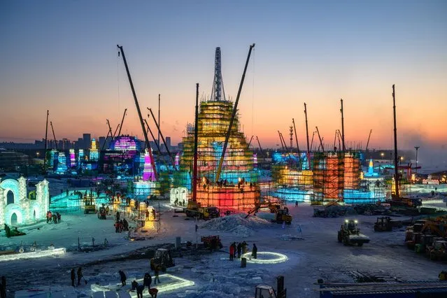 In this photo taken on December 10, 2023 workers build ice structures for the 25th Harbin Ice and Snow World in Harbin, in China's northern Heilongjiang province. (Photo by AFP Photo/China Stringer Network)
