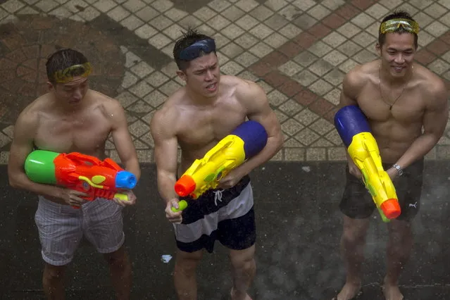 Revelers hold water guns as they participate in a water fight during Songkran Festival celebrations at Silom road in Bangkok April 12, 2015. (Photo by Athit Perawongmetha/Reuters)