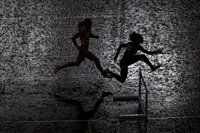 A general view of athletes in action during semifinal 3 as rain falls during the women's 400m hurdles at Olympic Stadium in Tokyo, Japan on August 2, 2021. (Photo by Hannah Mckay/Reuters)