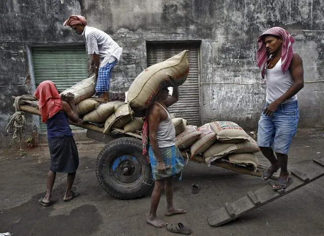 Labourers unload sacks of rice from a handcart at a wholesale market in Kolkata, India, in this December 14, 2015 file photo. (Photo by Rupak De Chowdhuri/Reuters)