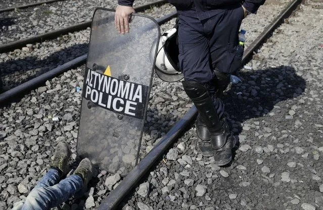 A Greek policeman stands on the railway tracks as migrants protest at the Greek-Macedonian border, near the village of Idomeni, Greece March 3, 2016. (Photo by Marko Djurica/Reuters)