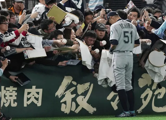 Seattle Mariners right fielder Ichiro Suzuki gives his autograph to fans prior to a pre-season exhibition baseball game between the Mariners and the Yomiuri Giants at Tokyo Dome in Tokyo Sunday March 17, 2019. (Photo by Eugene Hoshiko/AP Photo)