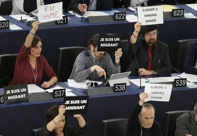 Members of the European Parliament hold leaflets with the slogans “I am a migrant” and “Europe sinking shame” at the end of a debate on the latest tragedies in the Mediterranean and E.U. migration and asylum policies at the European Parliament in Strasbourg, France, April 29, 2015. (Photo by Vincent Kessler/Reuters)