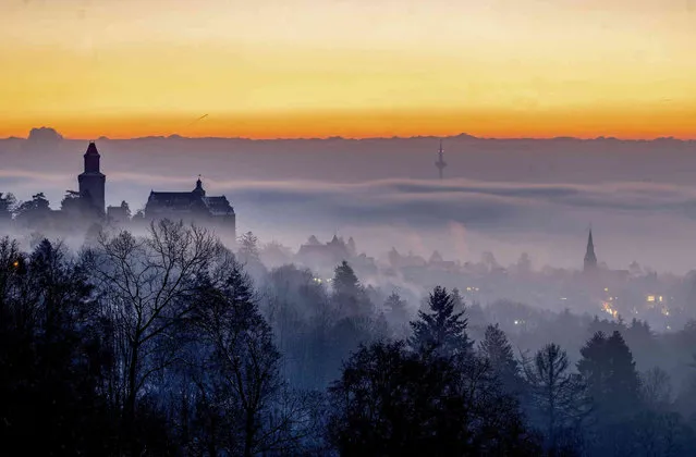 A view of the castle of Kronberg seen through fog, in Frankfurt, Germany, as the sun rises early Friday, January 19, 2024. (Photo by Michael Probst/AP Photo)
