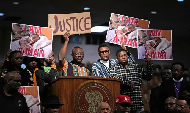 People hold signs during a news conference discussing the death of Tyre Nichols, Tuesday, January 31, 2023, in Memphis, Tenn. A funeral service for Nichols, who died after being beaten by Memphis police officers, is scheduled to be held on Wednesday. (Photo by Jeff Roberson/AP Photo)