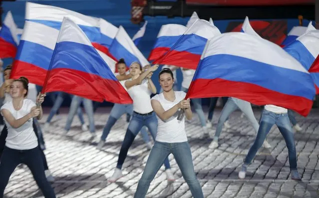 Performers dance with Russian national flags during a festive concert marking the 70th anniversary of the end of World War Two in Europe, at Red Square in Moscow, Russia, May 9, 2015. (Photo by Maxim Shemetov/Reuters)