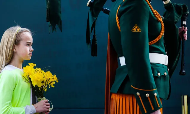 A young girl holds flowers during the Easter Sunday Commemoration Ceremony at the General Post Office on March 27, 2016 in Dublin, Ireland. Today marks the 100th anniversary of the Easter Rising in the Republic of Ireland when in 1916 a rebellion was attempted to oust British rule of the country. (Photo by Maxwells/Irish Government - Pool/Getty Images)