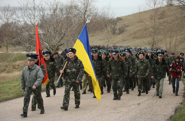 Colonel Yuli Mamchor (L), commander of the Ukrainian military garrison at the Belbek airbase, leads his unarmed troops to retake the Belbek airfield from soldiers under Russian command in Crimea on March 4, 2014 in Lubimovka, Ukraine. After spending a tense night anticipating a Russian attack following the expiration of a Russian deadline to surrender, in which family members of troops spent the night at the garrison gate in support of the soldiers, Mamchor announced his bold plan to his soldiers early this morning. (Photo by Sean Gallup/Getty Images)