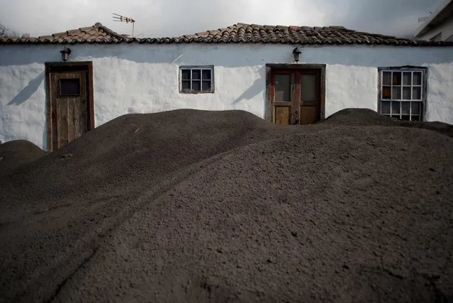 This photograph shows a house covered with lava following the eruption of the Cumbre Vieja volcano, in Las Manchas, on the Canary Island of La Palma on December 14, 2021. (Photo by Jorge Guerrero/AFP Photo)