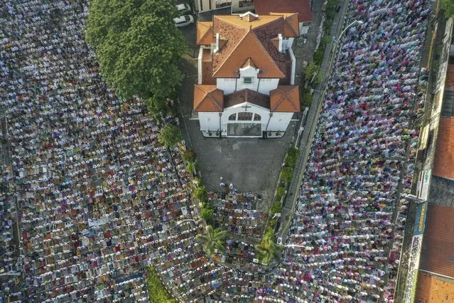 An aerial photo taken with a drone shows people performing Eid al-Fitr morning prayers outside of a church in Jakarta, Indonesia, 10 April 2024. Muslims worldwide celebrate Eid al-Fitr, a two or three-day festival at the end of the Muslim holy fasting month of Ramadan. It is one of the two major holidays in Islam. During Eid al-Fitr, most people travel to visit each other in town or outside of it and children receive new clothes and money to spend for the occasion. (Photo by Mast Irham/EPA)
