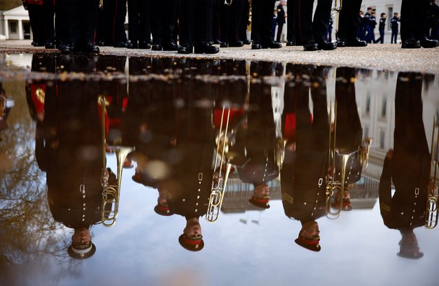 Members of the British Army's Band of the Grenadier Guards are reflected in a puddle as they take part in a rehearsal for a special Changing of the Guard ceremony, at Wellington Barracks in London on April 5, 2024, ahead of the 120th anniversary of the Entente Cordiale. France is to become the first non-Commonwealth country to take part in the Changing of the Guard ceremony at Buckingham Palace on April 8, 2024, with members of France's Gendarmerie Garde Republicaine set to take part for the 120th anniversary of the Entente Cordiale. (Photo by Benjamin Cremel/AFP Photo)