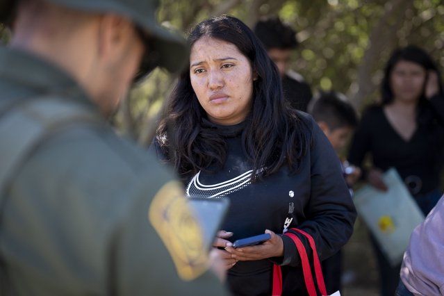 A migrant woman from Mexico talks with a Border Patrol agent before being transported in a van to be processed for asylum, Wednesday, June 5, 2024, near Dulzura, Calif. President Joe Biden on Tuesday unveiled plans to enact immediate significant restrictions on migrants seeking asylum at the U.S.-Mexico border as the White House tries to neutralize immigration as a political liability ahead of the November elections. (Photo by Gregory Bull/AP Photo)