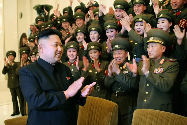 This undated photo released by North Korea's official Korean Central News Agency (KCNA) on March 12, 2014 shows North Korean leader Kim Jong-Un (C) applauding after the performance by the art squads of soldiers during the 1st contest of the Korean People's Army art squads at an undisclosed location in North Korea. (Photo by AFP Photo/KCNA via KNS)