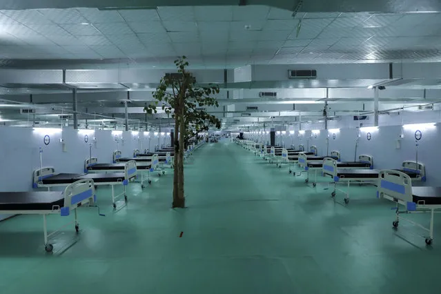 A tree stands at a facility for COVID-19 patients with 500 ICU beds that is being set up at Ramlila ground, a usual venue of major political rallies in New Delhi, India, Wednesday, May 12, 202. (Photo by Amit Sharma/AP Photo)