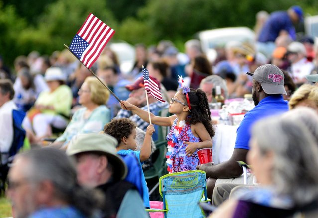 Gabriella Willams, 5, waves an American Flag during the "Symphony of Stars" as part of the 2024 Vermont Symphony Orchestra Summer Festival Tour in Grafton, Vt., Wednesday, July 3, 2024. (Photo by Kristopher Radder/The Brattleboro Reformer via AP Photo)