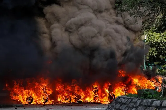 Motorbikes are on fire after they were hit with a molotov cocktail during a protest on China's National Day, in Wong Tai Sin, Hong Kong, China on October 1, 2019. (Photo by Tyrone Siu/Reuters)