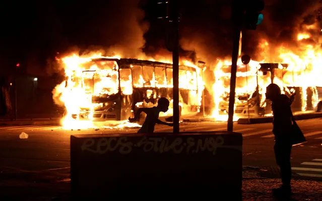 Buses burn during clashes between demonstrators and riot police in a protest against President Michel Temer's proposed reform of Brazil's social security system, in Rio de Janeiro, Brazil, April 28, 2017. (Photo by Ricardo Moraes/Reuters)