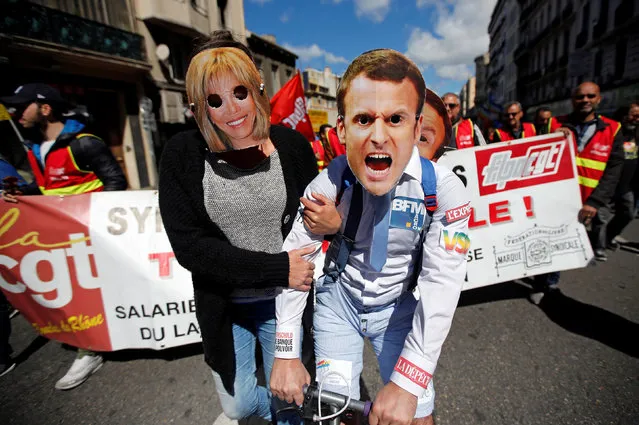 Demonstrators wearing masks depicting Emmanuel Macron (R), head of the political movement En Marche !, or Onwards !, and candidate for the 2017 presidential election and his wife Brigitte walk as part of traditional May Day labour day march in Marseille, France, May 1, 2017. (Photo by Jean-Paul Pelissier/Reuters)