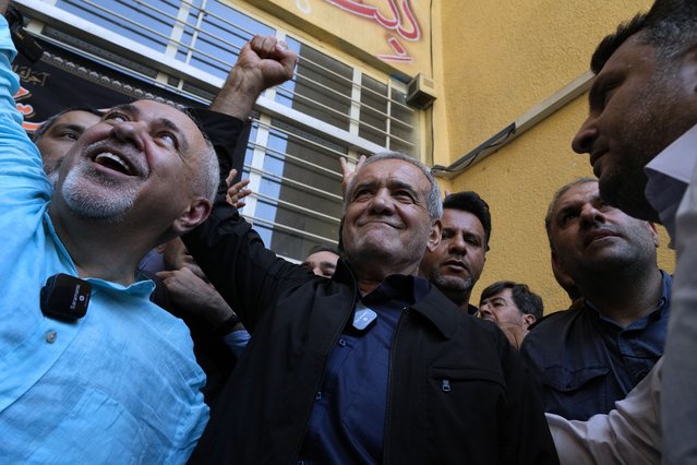 Reformist presidential candidate Masoud Pezeshkian raises a clenched after casting his vote in the presidential election, outside a polling station in Shahr-e-Qods, Iran, July 5, 2024. (Photo by Vahid Salemi/AP Photo)