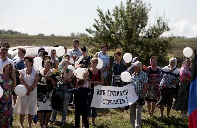 People take part in a commemoration ceremony at the site of the Malaysia Airlines flight MH17 plane crash near the village of Hrabove in Donetsk region, Ukraine, July 17, 2015. (Photo by Kazbek Basaev/Reuters)