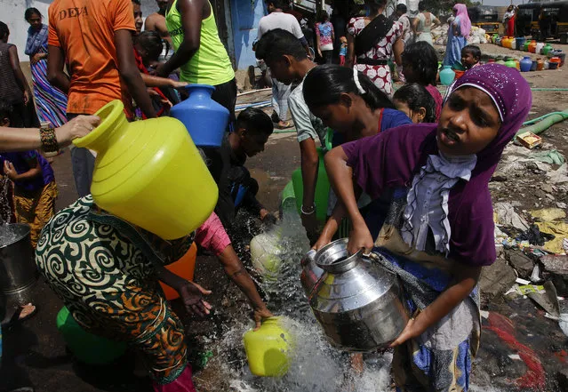In this April 30, 2016 file photo, people collect water for non-drinking use as the same is pumped out from a construction site at a slum area in Mumbai, Maharashtra state, India. Earth's heat is stuck on high. Federal scientists said the globe shattered monthly heat records for an unprecedented 12th straight month as April smashed the old record by half a degree. (Photo by Rajanish Kakade/AP Photo)