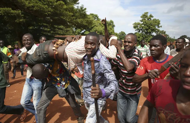 Protesters carry a man who was shot by French soldiers after French troops opened fire at protesters blocking a road in Bambari May 22, 2014. (Photo by Goran Tomasevic/Reuters)
