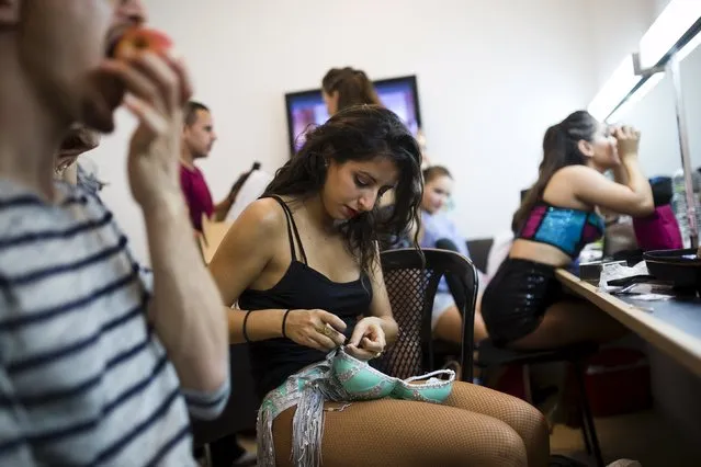 A participant repairs her costume backstage during a Latin dance competition in Tel Aviv, Israel July 18, 2015. (Photo by Amir Cohen/Reuters)