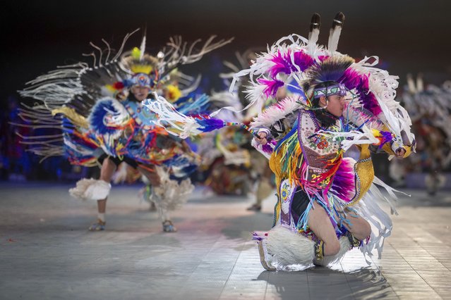 Thirteen year-old Leland Mitsuing, right, of Saskatchewan, Canada competes in the Jr. Boys Traditional competition at the 40th anniversary of the Gathering of Nations Pow Wow in Albuquerque, N.M., Friday, April 28, 2023. Tens of thousands of people gathered in New Mexico on Friday for what organizers bill as the largest powwow in North America. (Photo by Roberto E. Rosales/AP Photo)