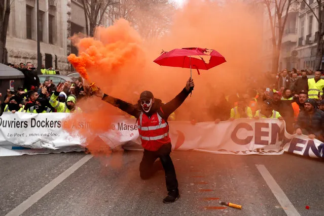 A protester holds a smoke torch during a demonstration against pension reforms in Marseille, France, 05 December 2019. Unions representing railway and transport workers and many others in the public sector have called for a general strike and demonstration to protest against French government's reform of the pension system. (Photo by Guillaume Horcajuelo/EPA/EFE)