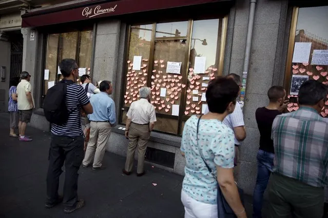 People look at messages on the windows of El Comercial cafe in Madrid, Spain, July 28, 2015.  El Comercial, which has been opened since 1887 and is the oldest cafe in Madrid, closed on Monday. (Photo by Juan Medina/Reuters)