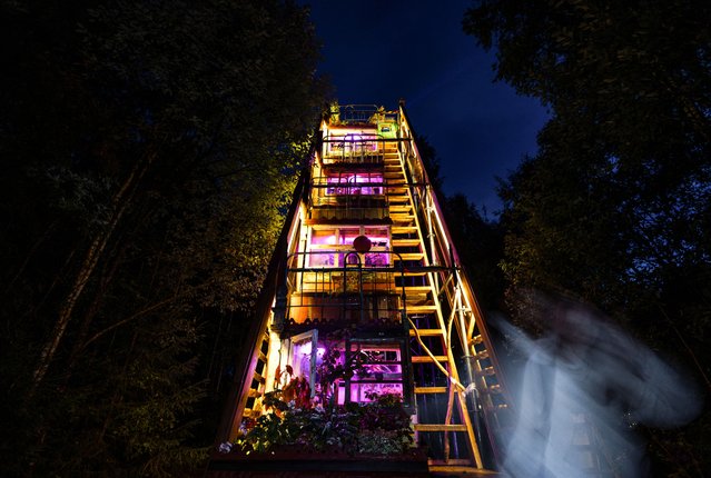 A woman passes by an art installation "Houses of the Earth: Theatre of Nature" by Russian artist Andrey Syailev during the Archstoyanie 2024 festival in the village of Nikola-Lenivets, Kaluga region, Russia on July 27, 2024. (Photo by Maxim Shemetov/Reuters)