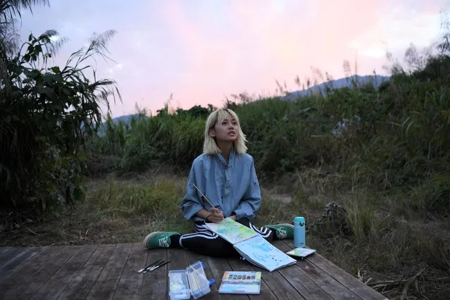 Chen Yan looks up as she paints on a hill during sunset at AnotherCommunity in Guanzhong village, Fuzhou, Fujian province, China on November 3, 2019. The small community preaches sustainable living and mindful consumption. China's teeming megacities have drawn hundreds of millions of people from rural villages and small towns in search of jobs and wealth, but people like Chen are part of an emerging trend in the opposite direction. (Photo by Tingshu Wang/Reuters)