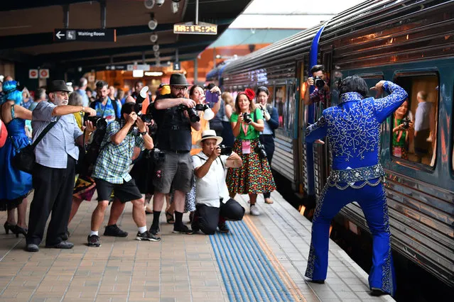 An Elvis impersonator poses for photographs at Central station before boarding a train to The Parkes Elvis Festival, in Sydney on January 9, 2020. (Photo by Dean Lewins/AAP)