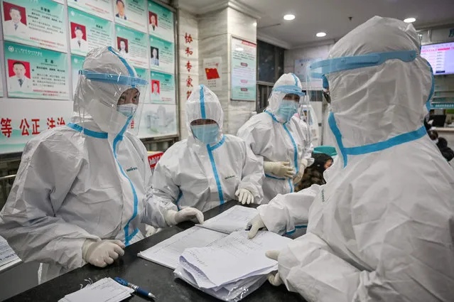 Medical staff members wearing protective clothing to help stop the spread of a deadly virus which began in the city, work at the Wuhan Red Cross Hospital in Wuhan on January 25, 2020. The Chinese army deployed medical specialists on January 25 to the epicentre of a spiralling viral outbreak that has killed 41 people and spread around the world, as millions spent their normally festive Lunar New Year holiday under lockdown. (Photo by Hector Retamal/AFP Photo)