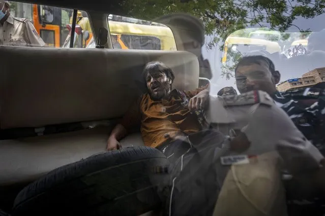 A student activist is tossed into a police vehicle during a protest demonstration against a new short-term government recruitment scheme for the military, in New Delhi, India, Friday, June 17, 2022. (Photo by Altaf Qadri/AP Photo)