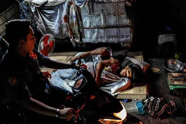 Police pass by homeless boys sleeping on the street during a night patrol, June 22, 2016, in Manila, Philippines. (Photo by Dondi Tawatao/Getty Images)