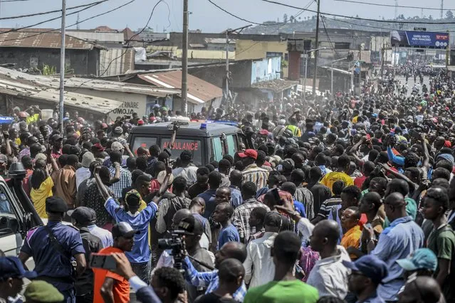 Residents fill the streets as they follow an ambulance containing the dead body of a Congolese soldier, in Goma, eastern Congo Friday, June 17, 2022. (Photo by Moses Sawasawa/AP Photo)