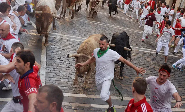 A runner sprints in front of Fuente Ymbro fighting bulls at the Estafeta corner during the first running of the bulls at the San Fermin festival in Pamplona, northern Spain, July 7, 2016. (Photo by Vincent West/Reuters)